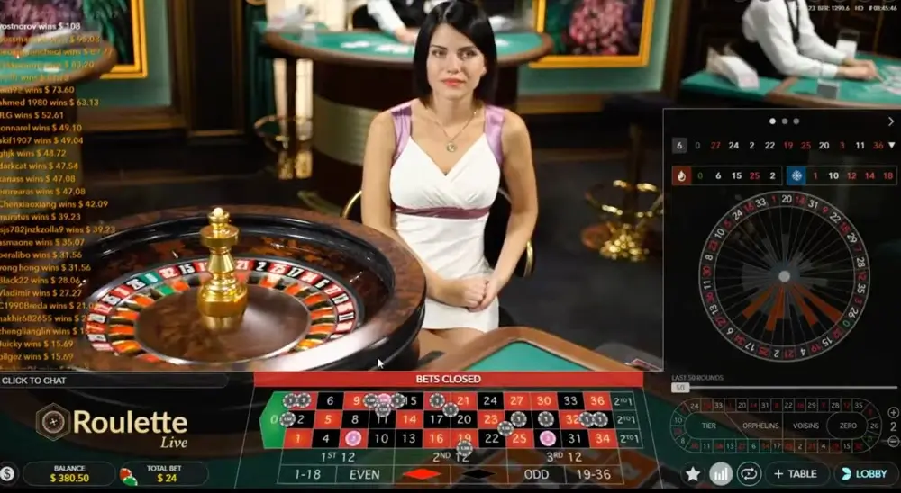 Live roulette dealer at spinning wheel with on-screen betting layout